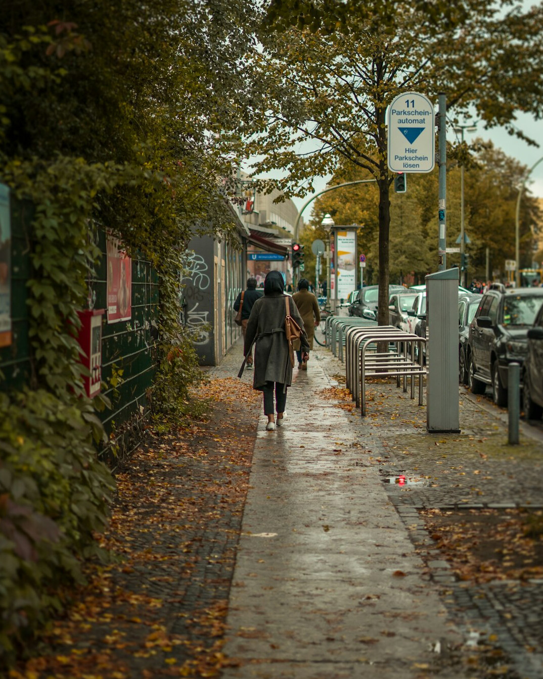 Person walking alone through a quiet German street seen from behind